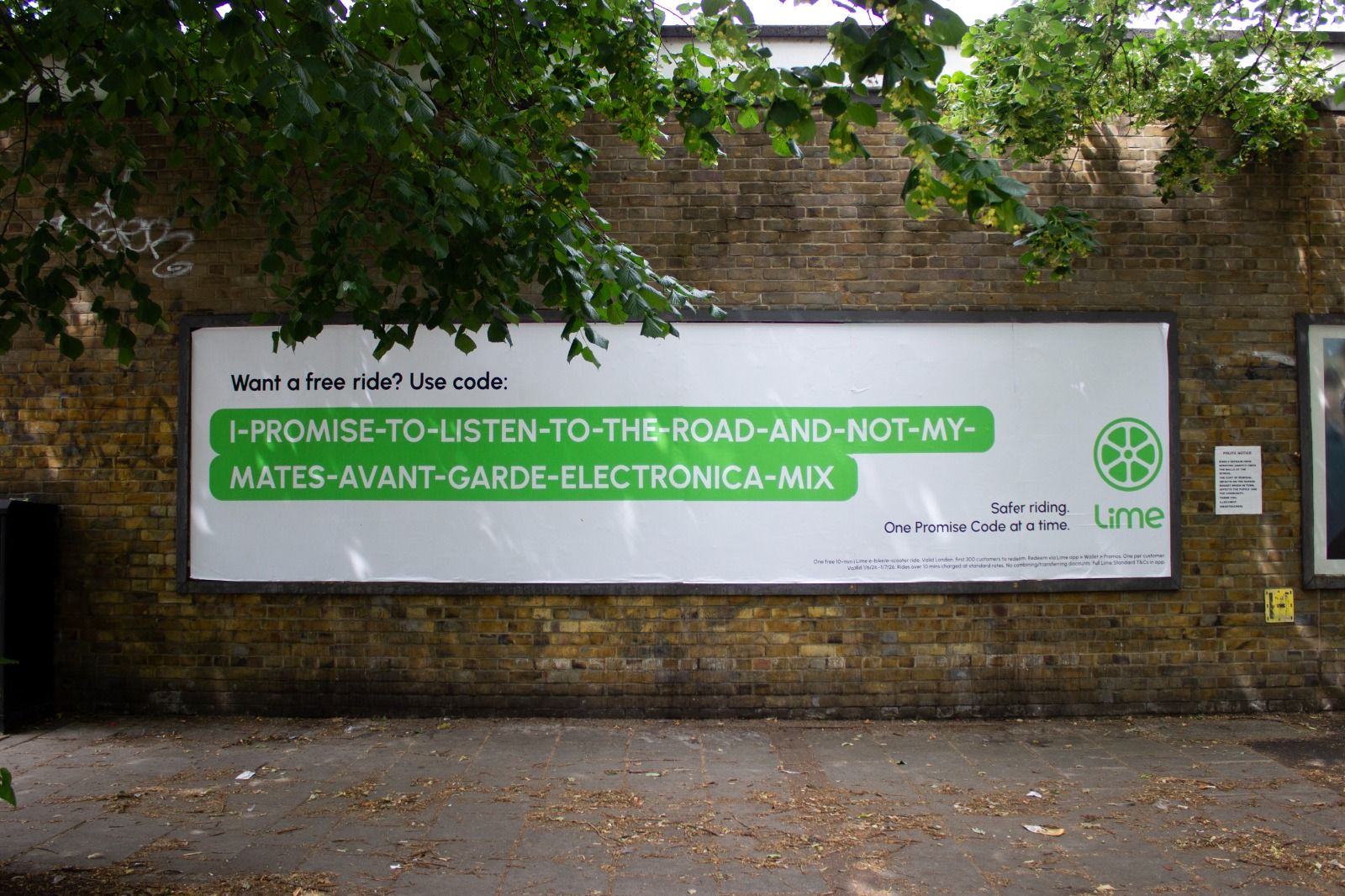 A Lime billboard on a London brick wall offering a free ride with the promo code 'I-PROMISE-TO-LISTEN-TO-THE-ROAD-AND-NOT-MY-MATES-AVANT-GARDE-ELECTRONICA-MIX' and the tagline 'Safer riding. One Promise Code at a time.'
