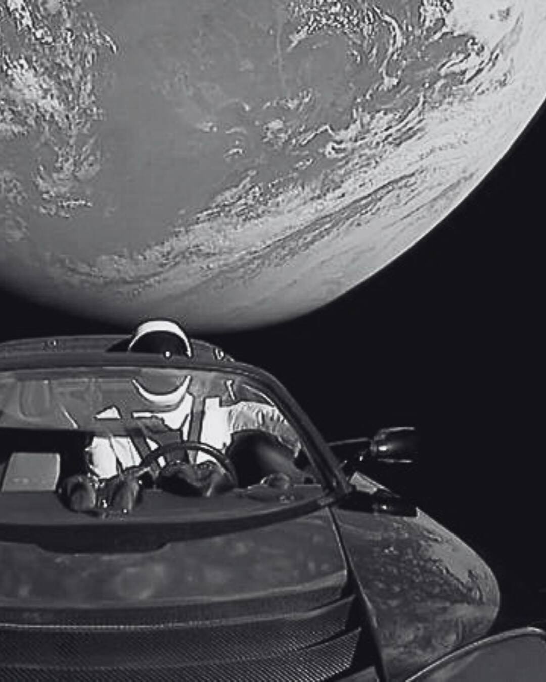 Elon Musk's Tesla Roadster in space with Earth in the background.